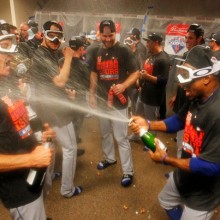 CINCINNATI, OH - SEPTEMBER 27: Curtis Granderson #3 of the New York Mets spray champagne on Bob Geren #15 as they celebrate in the clubhouse after defeating the Cincinnati Reds 10-2 to clinch the National League East Championship at Great American Ball Park on September 26, 2015 in Cincinnati, Ohio.  (Photo by John Sommers II/Getty Images)